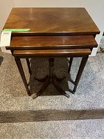 Full set of three wooden nesting tables showing tops and bases.
