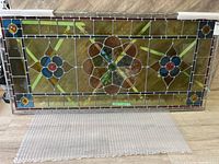 Overall front view of rectangular stained glass panel showing full decorative design and border