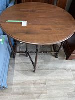 Top view of the round wooden table showing surface and dimensions tape attached.