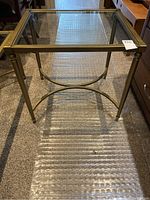 Rectangular coffee table with glass top and brass/gold metal frame shown from above