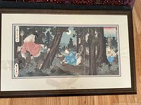 Woodblock triptych artwork visible fully framed, displaying the forest scene with multiple figures including a seated man with a white beard and two warriors under moonlight.