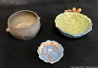 Three bowls displayed together on black background: bronze incense burner, green oak leaf bowl, blue Carlton Ware dish