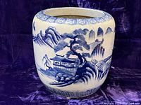 Full view of round blue and white porcelain hibachi on purple backdrop