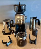 Full set of coffee appliances including Breville Smart Coffee Grinder, espresso pot, Nespresso frother, grind cup, and portafilter holders arranged on a table.