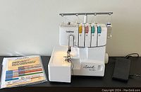 Brother Lock 1034D serger on table with manual binder and foot pedal