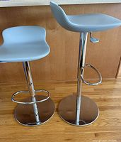Pair of bar stools side by side showing seat shape and chrome bases