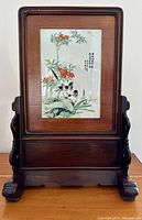 Full front view of porcelain plaque in hardwood frame and carved stand