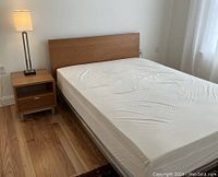 Full setup showing bed frame with headboard, nightstand, and lamp