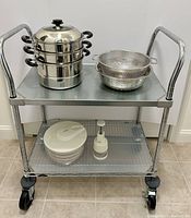 Full view of the rolling cart with steamer pot on top, colander, strainer bowls, salad spinner and food chopper on lower shelf