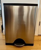 Front view of simplehuman dual compartment trash bin showing brushed stainless steel body and step pedal