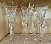 Six Waterford crystal flute glasses with Heart pattern shown upright on a shelf, highlighting clear crystal and etched heart designs.