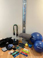 Overall assortment of exercise gear assembled against wall-mounted rail