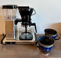 Full view of brewer assembled with carafe and two mugs