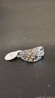 Silver tone ring with clear rhinestone accents in criss-cross design, tag showing size 17 attached