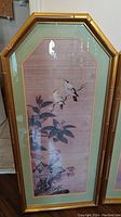 Framed painting with bamboo style solid wood frame showing birds and plants on beige background