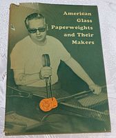 Front cover of the book showing man working glass and the title in yellow text.