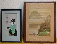 Photo showing both Japanese prints; the landscape with Mount Fuji on the right, the woman in green kimono on the left.