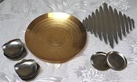 Overview of all items: goldplated bowl, trivet, stainless nut dishes, and floral dishes