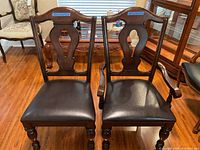 Front view of two side chairs and two armchairs grouped on wood floor under window