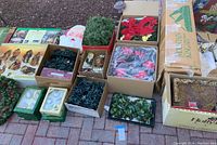 Wide view of boxed wreaths, lights, floral picks, ornaments and Nativity set boxes