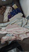 Photo showing several folded and stacked clothing items including pajamas and pants
