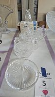 Full view of the Waterford crystal set showing two bells, a condiment set, and a bowl on a table.
