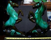 Photo showing both large ceramic horses in rearing position with a tape measure for scale, approx. 14" tall each.