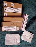 Photo showing labeled boxes for Guitar 3D Illusion Light, Trumpet 3D Illusion Light and handwritten trumpet labels along with wrapped contents.