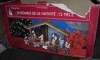 Box packaging of Holiday Time 12-piece nativity set showing manger and 9 figures including Mary, Joseph, baby Jesus, shepherds, wise men, and animals