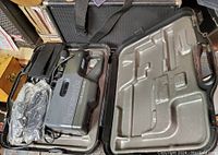 Panasonic OmniMovie VHS video camera and accessories inside black plastic hard case
