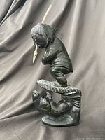 Side view of full sculpture showing hunter, iceberg ledge, and seal.