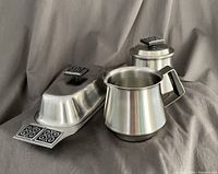 Butter dish, sugar bowl, creamer all photographed on gray fabric background showing designs and condition
