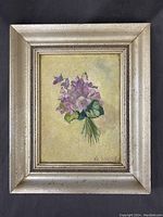 Front view of small framed vintage floral painting showing purple flowers and artist signature.