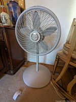 Front view of the white Lasko oscillating fan with a circular base and mesh grille.
