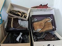 Overview of six pairs of women's shoes including boots and sandals in shoeboxes, various colors and brands.