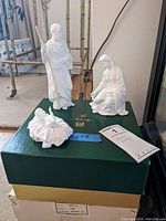 Full view of all three Lenox nativity figurines displayed on green Lenox box, showing Joseph with staff, Mary, and baby Jesus.