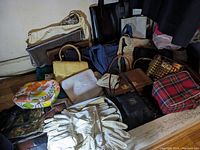 Overview of multiple purses, totes and vintage gloves on wooden surface