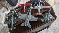 Top view of six different model airplanes on stands placed on table, showing variety of aircraft and color schemes.