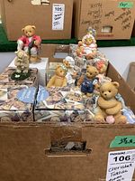 Box containing multiple Cherished Teddies figurines with original boxes inside a cardboard box showing various bears in different poses and outfits.