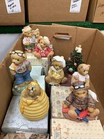 Box containing eight Cherished Teddies collectible bears on top of their original boxes inside a cardboard box.
