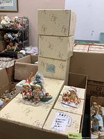 Overall view of stacked boxes with Cherished Teddies decorative pattern and several figurines on top, along with a label indicating approximately 20 pieces