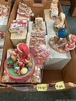 Top view of boxed collection showing about 9 pieces of Cherished Teddies figurines and music boxes with tags indicating sizes and pieces count.