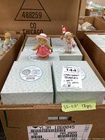 Box containing approximately 18 Cherished Teddies figurines in original packaging with label showing quantity and size range 3.5 to 4.5 inches.