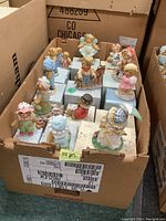 Box containing approximately 14 Cherished Teddies bear figurines with their boxes visible underneath