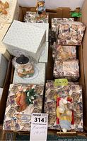 Lot of approximately 19 assorted Cherished Teddies figures, many still boxed, arranged in a cardboard box, showing variety of holiday-themed teddy bear figurines.
