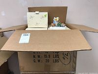 Box with Cherished Teddies Olga bear figurine partly visible inside, packaging shows floral pattern and Enesco brand marks.