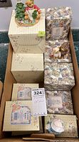 Lot of approximately 15 boxed Cherished Teddies figurines arranged in a cardboard box showing original packaging.