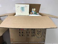 Open cardboard box showing multiple Cherished Teddies boxes stacked inside, indicating quantity and storage.