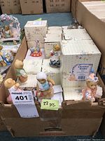 Box containing approximately 22 Cherished Teddies figurine boxes, individual figurines visible at front edges, in themed boxes.
