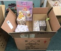 Box containing multiple Cherished Teddies figurines and Mother's Day gifts including packaging